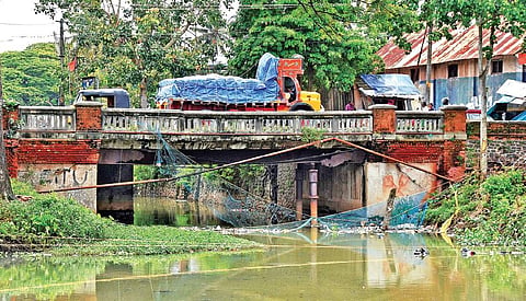 A fully loaded truck plies on the century-old dilapidated Vallakadavu bridge even though the authorities have prohibited heavy vehicles on the bridge B P Deepu