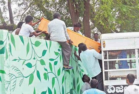 Carrying the coffin, the family members of a deceased person scaled the cemetery wall in Vijayawada on Saturday to perform the last rites | Express