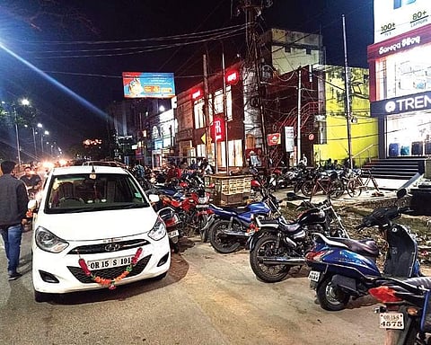 Vehicles parked illegally on a road in front of a shopping mall