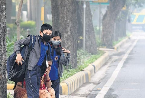 Students cover their faces with masks to protect themselves from morning air pollution, at Firoz Shah Road. (Photo | EPS, Parveen Negi)