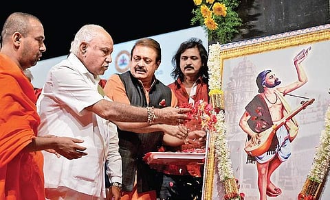 Chief Minister B S Yediyurappa offers flowers to a painting of philospher and poet Kanakadasa at Ravindra Kalakshetra in Bengaluru on Friday | meghana sastry