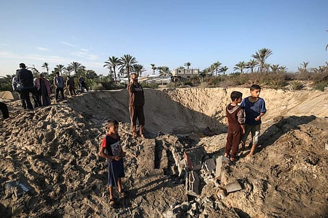 Palestinian children stand around a crater caused by an Israeli airstrike launched in response to rocket fire, in Khan Yunis in the southern Gaza Strip on November 2, 2019 (Photo| AFP)