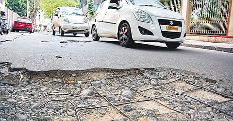 Cars parked on roads that are in poor condition in Bengaluru.