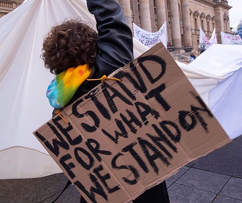 A demonstrator holds a white cloth as a symbol of a fresh start in the climate politics during a protest climate strike ralley of the 'Friday For Future Movement' in front of the Federal Administrative Court building in Leipzig, Germany, Friday, Nov. 29,