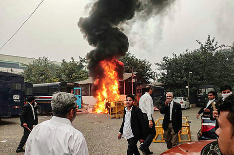 A view of a police vehicle being burnt down during clashes between lawyers and police personnel at Tis Hazari Court complex in New Delhi. (Photo | PTI)