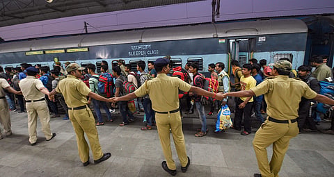 Security personnel form a human chain as workers arrive at the station from Jammu and Kashmir in Kolkata Monday Nov. 4 2019. | (Photo | PTI)
