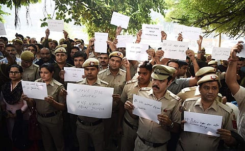 Delhi Police officials holding posters during a protest demonstration against the recent attack by lawyers at the Police headquarters in New Delhi on Tuesday. (Photo | Parveen Negi, EPS)