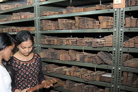 Students looking at manuscripts at Oriental Research Institute in Mysuru. (Photo | Express)