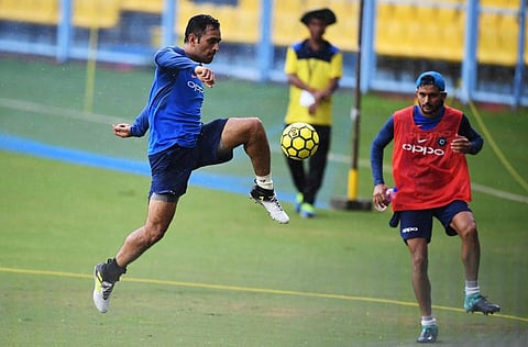 India's Mahendra Singh Dhoni (L) plays a game of football during a training session. (Photo | AFP)