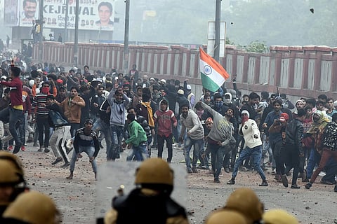 Demonstrators throw pieces of bricks towards police officers during a protest against a new citizenship law in Seelampur area of Delhi December 17 2019. (Photo | Parveen Negi/EPS)