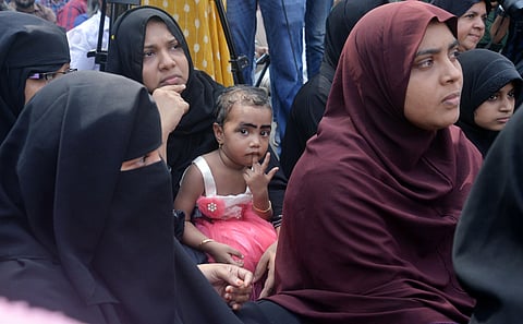 A child participating in a protest as part of the hartal organised by SDPI Welfare party, BSP Porattam DRHM and other umbrella organisations in front of the secretariat against the Citizenship Amendment Act on Tuesday sitting on the lap of an agitating bu
