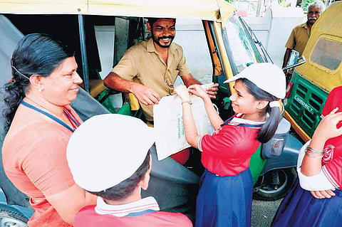 Students of Little Flower UP School in Kaloor, along with their teacher, selling cloth bags made by them to autorickshaw drivers.