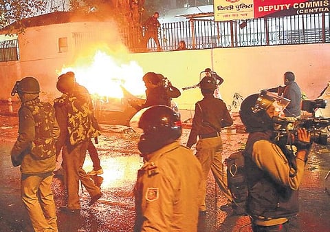 Police and media personnel outside the DCP Central’s office in Daryaganj where protesters set ablaze a car on Friday evening. (Photo | EPS, Shekhar Yadav)