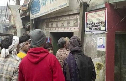People look at a poster carrying photos of protesters who went violent on December 20 (Photo| ANI)