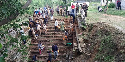 Volunteers, Home Guards and Army personnel clean a dried-up open well in a village in rural Bengaluru on Tuesday