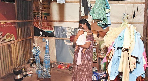 Amid muck and ruins, this mother, who had to hand over her four children to the District Child Welfare Committee due to financial constraints, rocks her child in a cradle to sleep at Kaithamukku in Thiruvananthapuram on Monday night | B P DEEPU