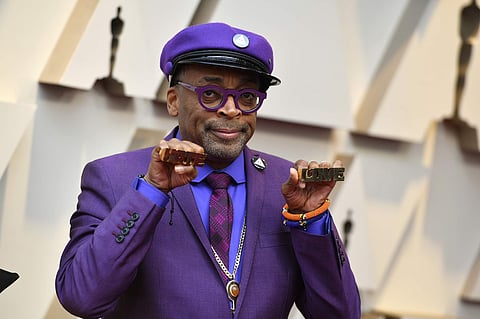 Spike Lee holds up brass knuckles reading 'hate' and 'love' from his iconic film 'Do The Right Thing' as he arrives at the Oscars on Sunday, Feb. 24, 2019, at the Dolby Theatre in Los Angeles. (Photo | AP)