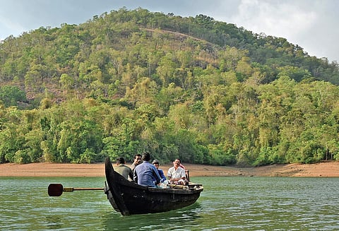 Residents of Puravimala tribal settlement near Amboori crossing Karippar river in a boat B P Deepu