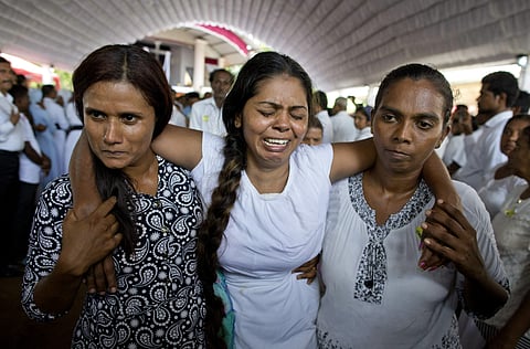 A grieving woman is supported during a funeral service attended by Cardinal Malcolm Ranjith for Easter Sunday bomb blast victims at St. Sebastian Church in Negombo, Sri Lanka on 23 April 2019. (Photo | AP)