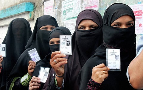 A file photo of Muslim voters showing their voter identity cards before casting their vote for the Assembly elections at a polling station. (Photo | PTI)