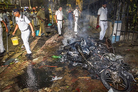 Police personnel douse burning vehicles caused by a mob during BJP President Amit Shah's election roadshow in Kolkata (Photo | PTI)