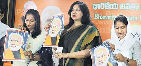 BJP leader Karuna Gopal stands with torn copies of the TIME magazine cover in Hyderabad on Friday | Satha Keerthi
