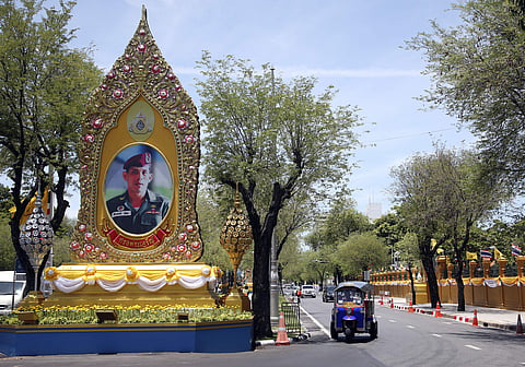 A three-wheel drives beside a giant portrait of Thailand's King Maha Vajiralongkorn Bodindradebayavarangkun in Bangkok (Photo | AP)