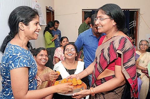 V Muraleedharan’s wife K S Jayasree (right) distributes sweets at their house in Kozhikode on Thursday during the former’s oath-taking ceremony | T P Sooraj