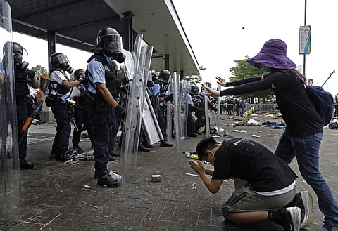 A protester bows to riot police after they fire tear gas towards protesters outside the Legislative Council in Hong Kong, Wednesday, June 12, 2019. (Photo | AP)