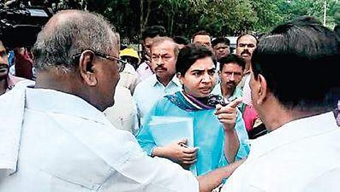 Shivamogga City Corporation Commissioner Charulata Somal and MLC Ayanur Manjunath have an argument in Shivamogga on Tuesday. D C Thammanna looks on | Express