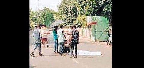 Family members of deceased pregnant woman protest with her body lying on the road alongside. (Photo | EPS)