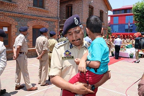 Haseeb Mughal, the Senior Superintendent of Police in Srinagar, breaks down while carrying the 4-year-old son, Uhbaan of inspector Arshad Khan who died in the Anantnag encounter on 17 June 2019. (Photo | Twitter)