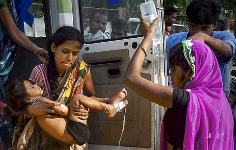 A woman carrying a child showing symptoms of Acute Encephalitis Syndrome. (Photo| PTI)