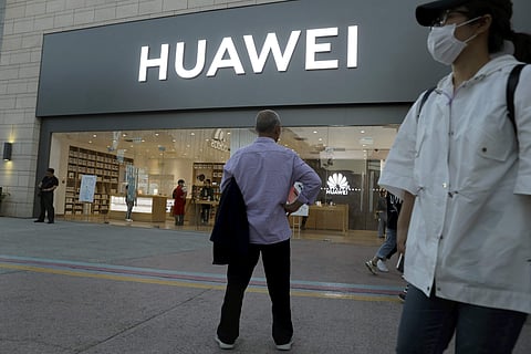 In this photo taken Monday, May 20, 2019, a man stands outside a Huawei store in Beijing. The Financial Times reported Friday, May 31, 2019 that tech giant Huawei has ordered its employees to cancel technical meetings with American contacts and has sent h