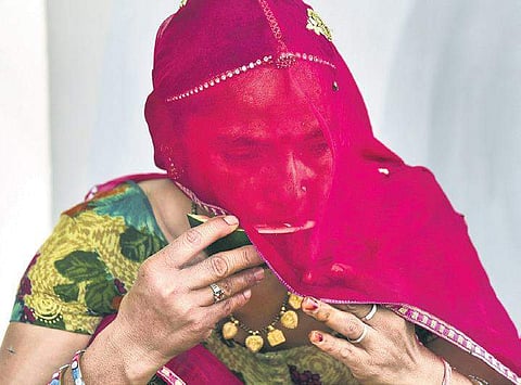 A woman eats watermelon on a hot, summer day as the temperature soared in Bikaner city in northern Rajasthan, which has been swept by a heatwave | PTI