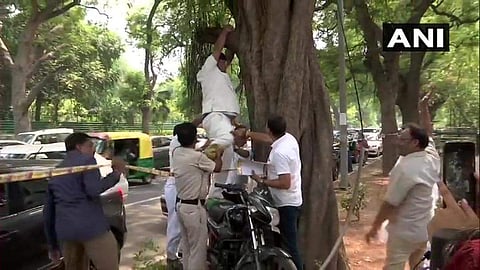 Congress worker who tried to commit suicide being rescued by cops in Delhi. (Photo | ANI, Twitter)