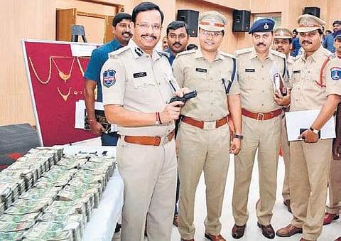 Police officials display the toy gun used by the gang, and the stolen gold and cash worth Rs 3.20 crore seized from them at the Shadnagar Police Station on Wednesday (Photo| EPS)