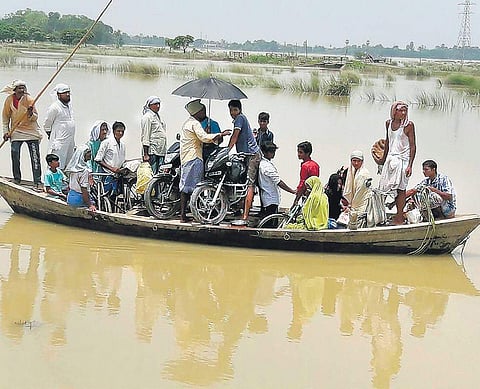 People use a boat to move across a flooded area in Darbhanga, Bihar | PTI
