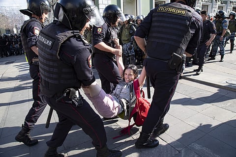 Police officers detain a woman during an unsanctioned rally in the center of Moscow, Russia. (Photo | AP)