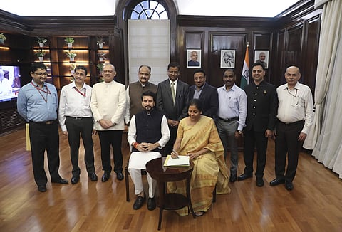 Finance Minister Nirmala Sitharaman, seated right, signs the Indian federal budget after giving final touches, as MoS Finance and Corporate Affairs Anurag Thakur, seated left, watches along with finance budget team at her office in New Delhi, India, July