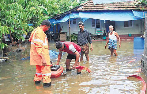 Vedimara resident Abdul Khader along with Fire and Rescue Services officials pump out water in front of his house in North Paravoor. (Photo | Arun Angela)