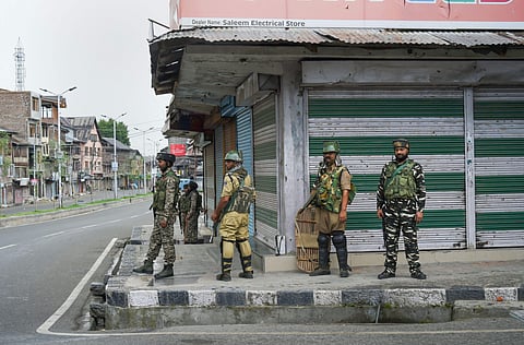 Security personnel stand guard during curfew like restriction in Srinagar. (Photo | PTI)
