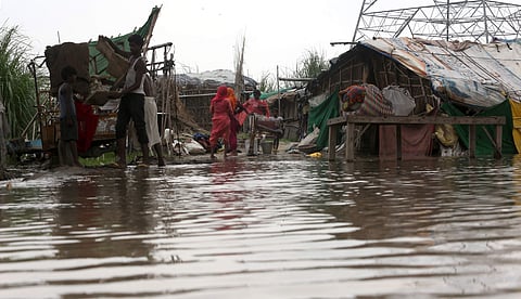 People are seen next to their half submerged makeshift house in the low-lying area near the banks of the Yamuna river in New Delhi on Monday August 19 2019. | (Shekhar Yadav | EPS)
