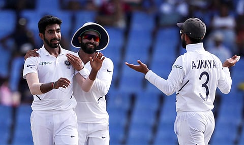 India's Jasprit Bumrah is congratulated by teammates after taking the wicket of West Indies' captain Jason Holder during day four of the first Test cricket match at the Sir Vivian Richards cricket ground in North Sound. (Photo | AP)