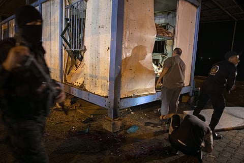 Palestinians check a damaged police container following an explosion targeted a Hamas police checkpoint in Gaza City. (Photo | AP)