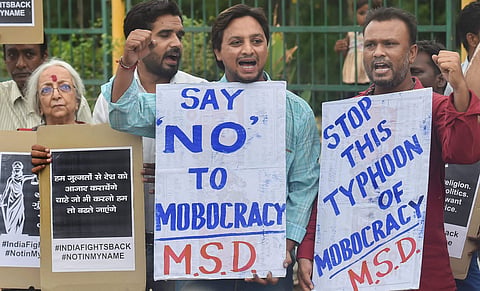 People raise slogans and hold placards as they protest against mob lynching. (File Photo | PTI)