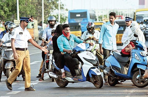 File photo: Police enforcing the compulsory helmet rule near Kamarajar Salai. | Ashwin Prasath