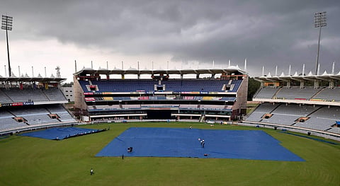 Groundsmen cover the pitch as dark clouds are seen in the sky over JSCA Stadium in Ranchi. (File| PTI)