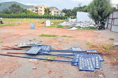Revenue officials put up a notice board after demolishing the illegal structure in the govt land near Madhurnagar rly station in Vijayawada (Photo |EPS, P Ravindra Babu)