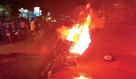 Villagers set a police vehicle on fire after a woman biker was injured in a road accident which was caused due to a vehicle check conducted by police | Express